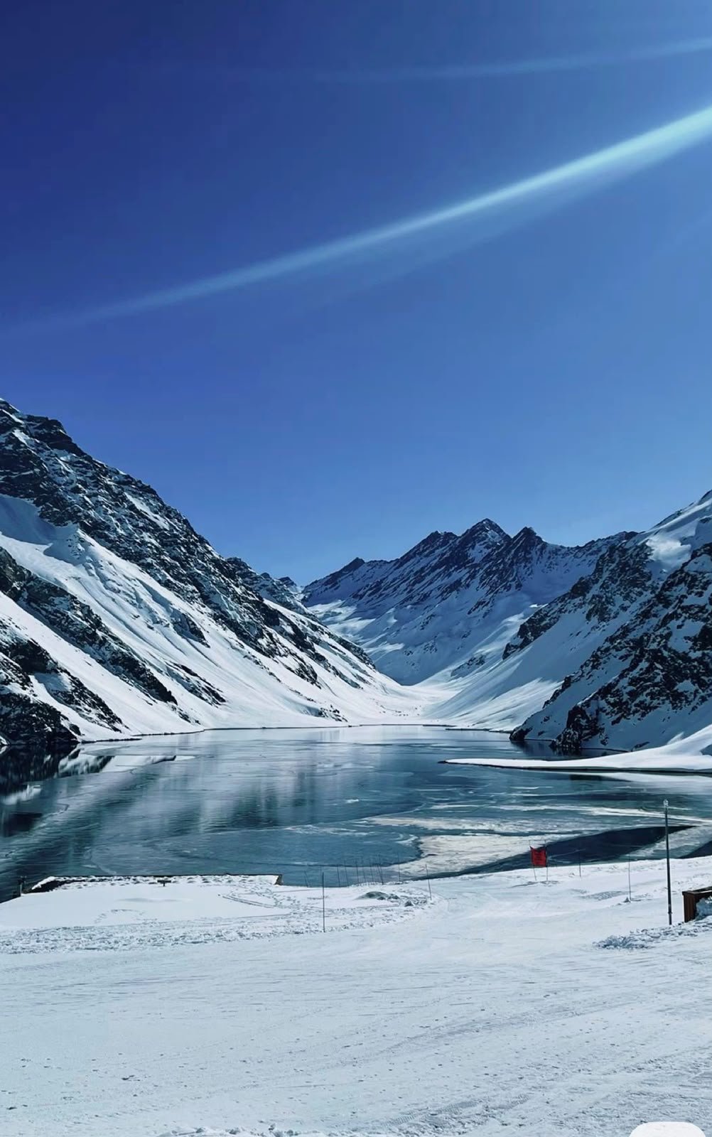 Lago congelado entre montanhas nevadas na cordilheira dos Andes, no Chile