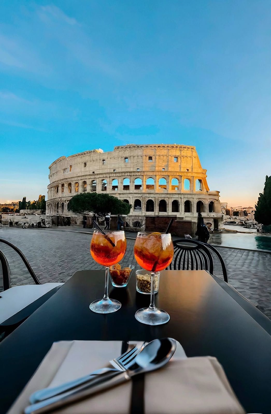 Coliseu de Roma ao entardecer visto de uma mesa de bar